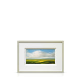 Framed Harry Brioche artwork of a landscape with green fields and blue sky.