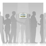 Silhouettes of people standing in front of a framed Harry Brioche picture on a wall.