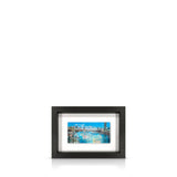 A framed artwork depicting a view from Waterloo Bridge, with a black frame.